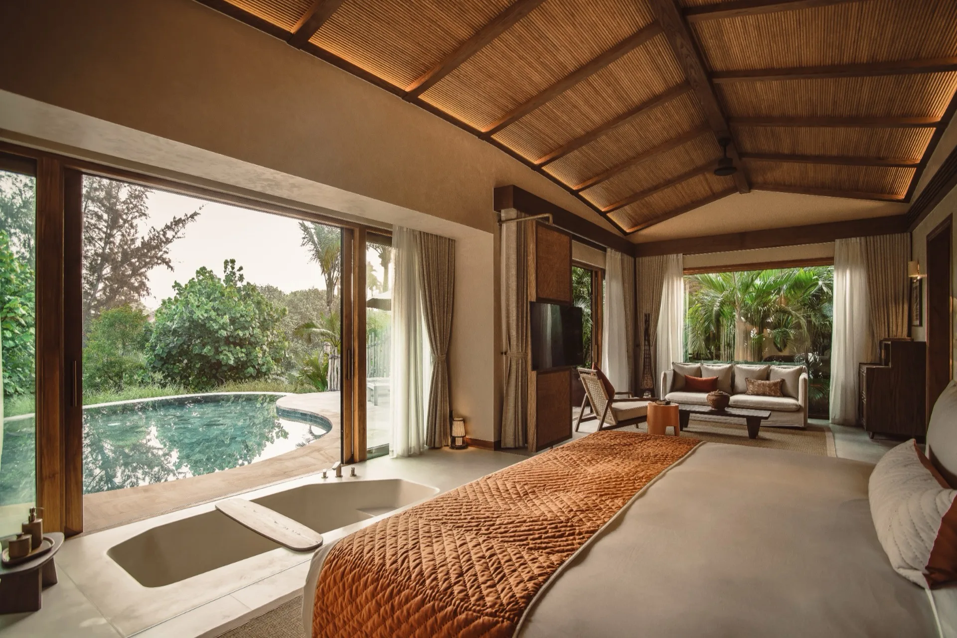 A private pool villa at Namia River Retreat, opening onto a pool surrounded by tropical greenery